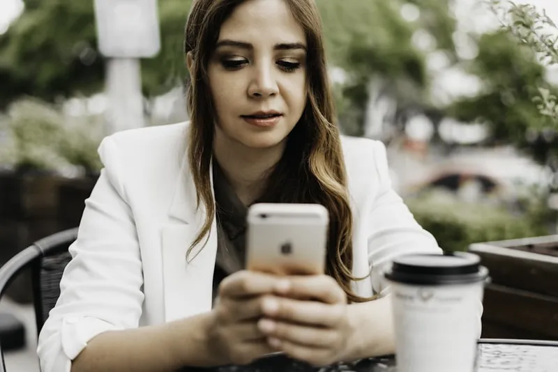 Professional woman browsing on her smartphone at a cafe